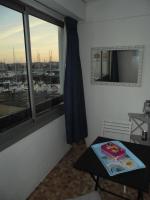 a room with a table and a window with a view of a harbor at Vue Mer 180° Parking+Lave-Linge+Proche Plages+Piscine in Cap d&#39;Agde