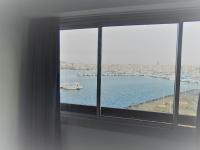 a room with a window with a view of a harbor at Vue Mer 180° Parking+Lave-Linge+Proche Plages+Piscine in Cap d&#39;Agde