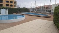 two swimming pools on a patio with a marina at Vue Mer 180° Parking+Lave-Linge+Proche Plages+Piscine in Cap d&#39;Agde