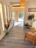 sala de estar con suelo de madera, sofá y ventanas en Villa d&#39;architecte avec piscine et grand jardin, en Marsella