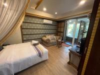 a bedroom with a bed and a couch and a television at Ming Jun Homestay in Eluan