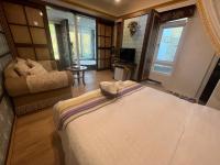 a bedroom with a large bed and a living room at Ming Jun Homestay in Eluan