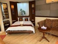 a bedroom with a bed and a couch and a table at Ming Jun Homestay in Eluan