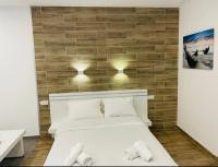 ein Schlafzimmer mit einem weißen Bett und einer Ziegelwand in der Unterkunft Eilat Charming Studio-Balcony in Eilat
