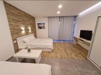 ein Wohnzimmer mit einem Bett und einem Fernseher in der Unterkunft Eilat Charming Studio-Balcony in Eilat