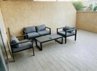 eine Terrasse mit einem Sofa, 2 Stühlen und einem Tisch in der Unterkunft Eilat Charming Studio-Balcony in Eilat