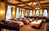 Hotel Haikko Manor & Spa في بورفو: غرفة طعام مع طاولات وكراسي وثريات