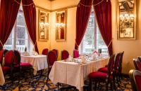 Hotel Haikko Manor & Spa في بورفو: غرفة طعام مع طاولتين وكراسي حمراء