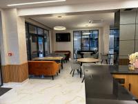 ein Restaurant mit Tischen, Stühlen, Tischen und Fenstern in der Unterkunft Emilia Romana Park in Sonnenstrand