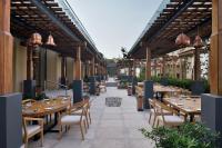 um pátio exterior com mesas e cadeiras de madeira em The Westin Resort & Spa Himalayas em Rishikesh