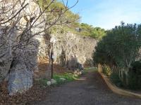 a dirt road with trees and a stone wall at Apartment Eden Roc 2 by Interhome in Narbonne-Plage