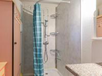 a shower with a blue shower curtain in a bathroom at Apartment Eden Roc 2 by Interhome in Narbonne-Plage