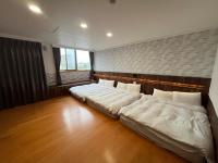 a bedroom with two beds and a brick wall at Dongshan River Resort Farm in Wujie