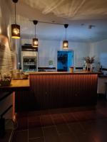 una cocina con encimera y barra en Gamla Järnhandeln - Norrskedika Hotell, en Östhammar