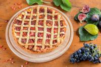 コペルにあるŠtok - Rooms, Wine & Restaurant - Marezige, Koperの木のテーブルの上にフルーツが添えられたパイが置かれている