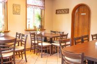 a restaurant with tables and chairs and a clock on the wall at Landhaus Müden in Faßberg