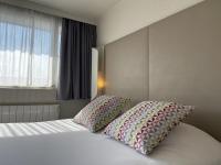 a bedroom with a bed with two pillows on it at Campanile Valence Sud in Valence