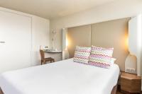 a bedroom with a large white bed with two pillows at Campanile Valence Sud in Valence