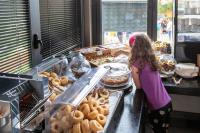Una niña parada frente a una panadería en hu Roma Camping In Town, en Roma