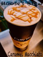 een kop koffie met een karamelmolecuul erop bij Carlo Creek Cabins in McKinley Park