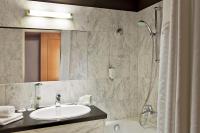 a bathroom with a sink and a mirror and a tub at Holiday Inn Vienna City by IHG in Vienna