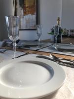 a table with a white plate and two wine glasses at Belle vue sur mer, très près du port de Sanary in Sanary-sur-Mer