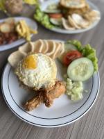um prato de alimentos com um ovo e carne e produtos hortícolas em Hotel Nature Bromo and Resort em Pasuruan