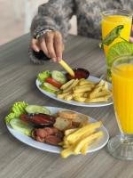 dois pratos de comida numa mesa com dois copos de sumo de laranja em Hotel Nature Bromo and Resort em Pasuruan