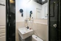 a bathroom with a sink and a toilet and a mirror at Apartments WS Tour Eiffel - Laos in Paris