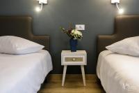 un dormitorio con 2 camas y una mesa con un jarrón de flores en Pensiunea AS, en Floreşti