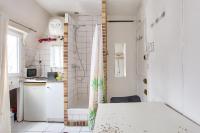 eine kleine Küche mit Duschvorhang in einem Zimmer in der Unterkunft Cosy studio in the 8th arr 4 min from Rome metro in Paris