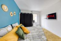 a bedroom with a bed with colorful pillows at Charmant T2 proche de Disney in Noisy-le-Grand