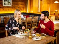 トゥルラッハー・ヘーエにあるHotel Turracherhofの男性と女性がテーブルに座って食事している