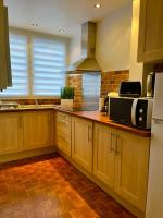 a kitchen with wooden cabinets and a microwave at Escapade jacuzzi in Caen