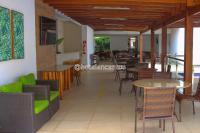 um restaurante com mesas e cadeiras e uma mesa e cadeiras em Hotel Encantos de Itaperapuã em Porto Seguro