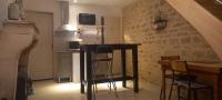 a kitchen with a table and chairs in a room at Le cottage du village in Seigny