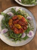a plate of food with tomatoes and greens on a table at Maison 1643 in Laudun