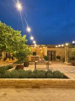 a patio with a table in front of a building with lights at Casa La Siesta in Vejer de la Frontera