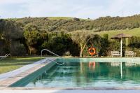 a swimming pool in a yard with an umbrella at Casa La Siesta in Vejer de la Frontera