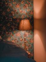 a lamp in a bedroom with a floral wallpaper at Vakantiewoning De Luysmolen in Bocholt