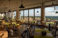 Un restaurante con mesas y sillas y grandes ventanales. en Eco complex Zdravets near Varna, en Zdravets
