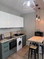 a kitchen with a table and a washing machine at Le Petit Hernoux Centre historique in Dijon