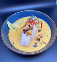 een blauw bord met een stuk vis in een soep bij Mercure Orléans Centre Bords de Loire in Orléans