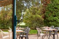 una fila de mesas y sillas en un jardín en Kyriad Direct Epinal, en Épinal