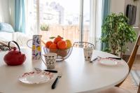 a table with plates and a bowl of fruit on it at Apt lumineux et très cosy avec balcon by Weekome in Marseille