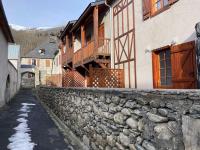 a building with a stone wall next to a street at Appartement Vignec, 2 pièces, 6 personnes - FR-1-504-176 in Vignec