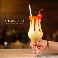 een persoon die een drankje vasthoudt met een kers erop bij El Portal Del Marques in Cajamarca