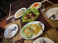 Una mesa de madera con platos de comida encima. en Bundala Flamingo Cotteges, en Hambantota
