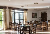 uma sala de jantar com mesas, cadeiras e janelas em Hotel Tugasa Sierra y Cal em Olvera