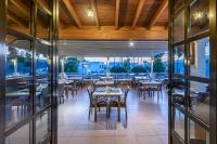 una sala da pranzo con tavoli, sedie e finestre di Palladium hotel a Marmári